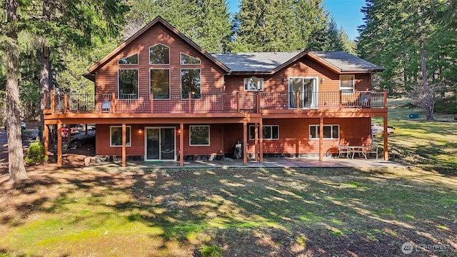 rear view of property with a patio area, a lawn, and a wooden deck