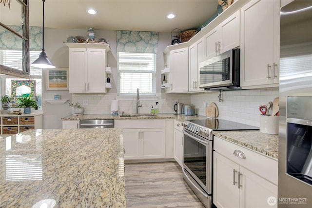 kitchen featuring appliances with stainless steel finishes, backsplash, a sink, and white cabinets