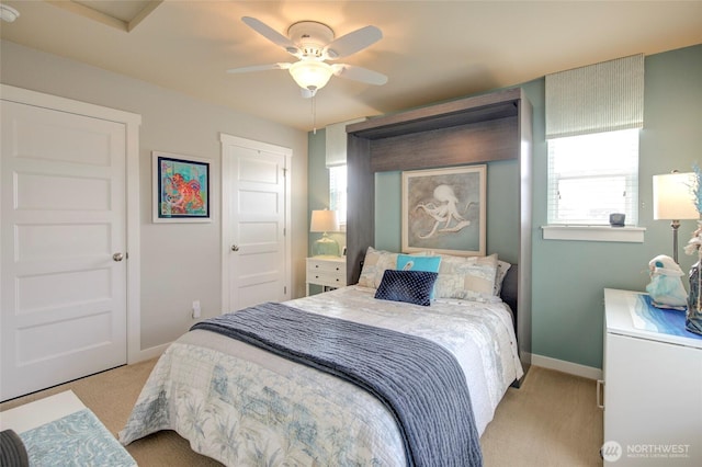 carpeted bedroom featuring baseboards and a ceiling fan