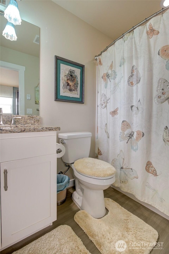 full bathroom with visible vents, vanity, toilet, and wood finished floors