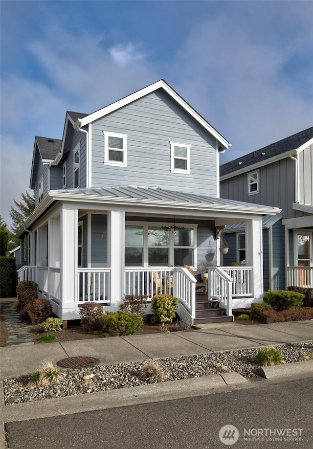 view of front facade featuring a standing seam roof, metal roof, and a porch