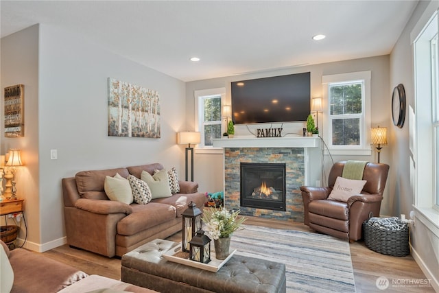 living room with a fireplace, wood finished floors, and baseboards