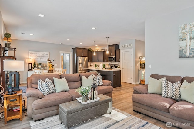 living room featuring baseboards, light wood-type flooring, and recessed lighting