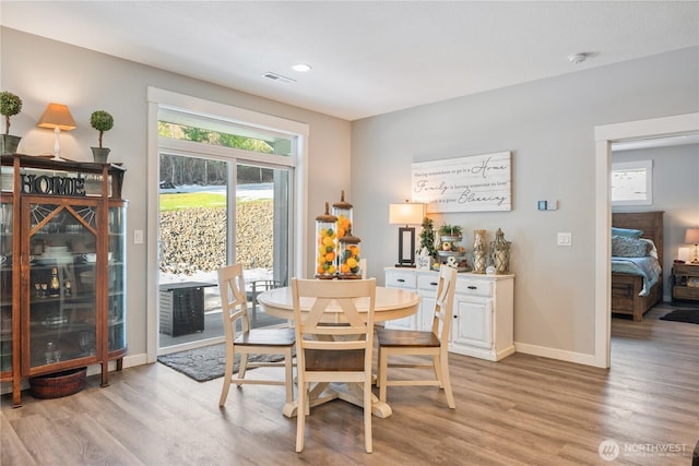 dining room featuring light wood finished floors, baseboards, visible vents, and recessed lighting