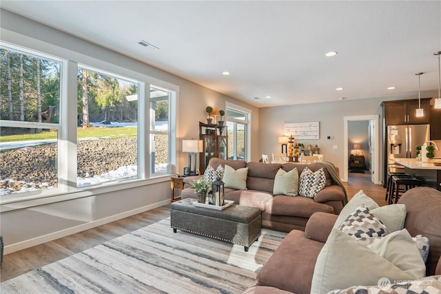 living room with baseboards, light wood-type flooring, and recessed lighting