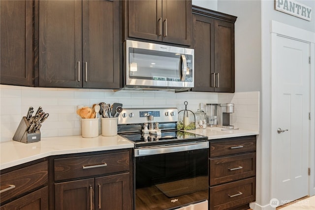 kitchen featuring decorative backsplash, stainless steel appliances, dark brown cabinets, and light countertops