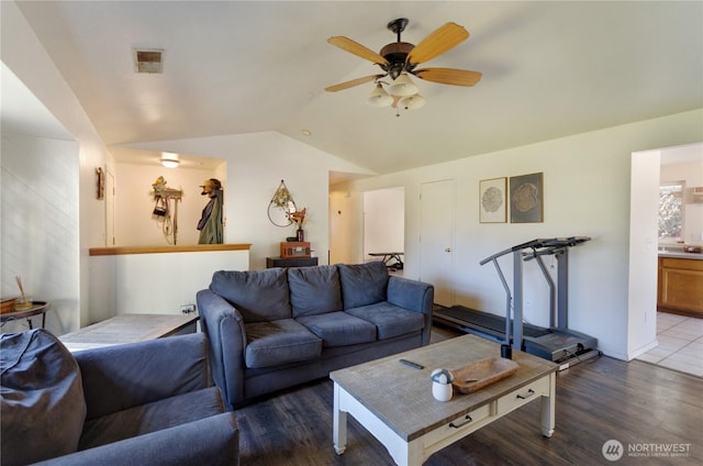 living area with lofted ceiling, visible vents, ceiling fan, and wood finished floors