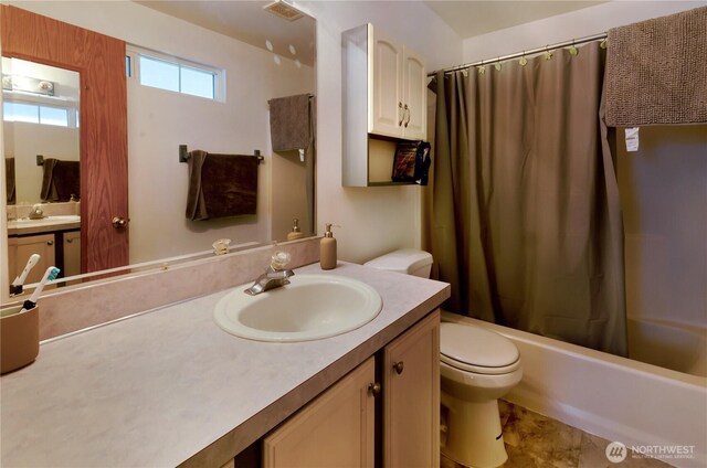 bathroom with visible vents, shower / bath combo, vanity, and toilet