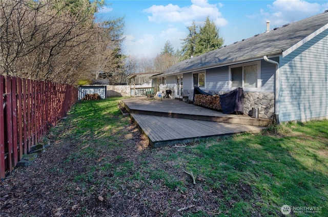 view of yard with a deck, an outbuilding, and a fenced backyard