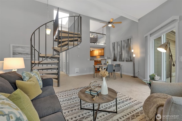 carpeted living area with visible vents, a towering ceiling, ceiling fan, baseboards, and stairs