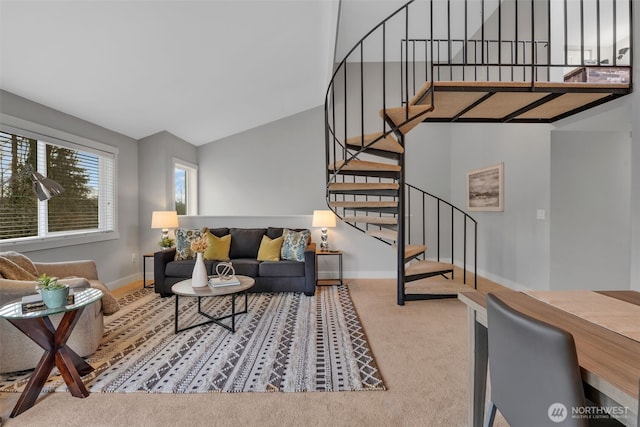 carpeted living area with stairs, baseboards, and vaulted ceiling