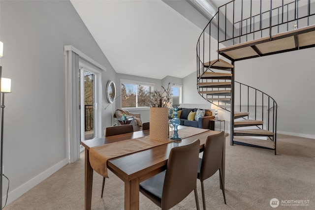 dining area featuring high vaulted ceiling, carpet flooring, stairway, and baseboards