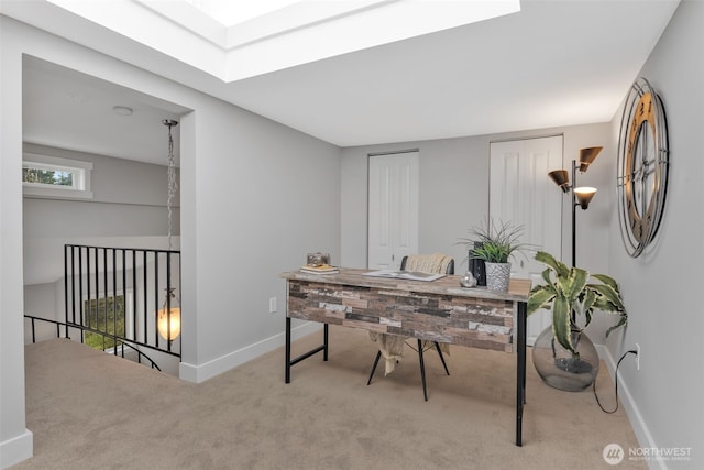 carpeted home office with a skylight and baseboards