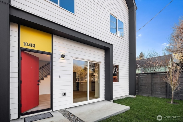 property entrance with a yard and fence