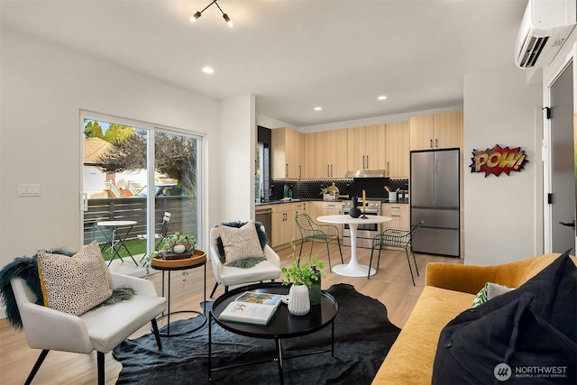 living area with light wood-style floors, recessed lighting, and a wall mounted AC