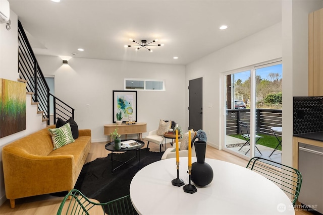 living room with stairs, light wood finished floors, a wall unit AC, and recessed lighting