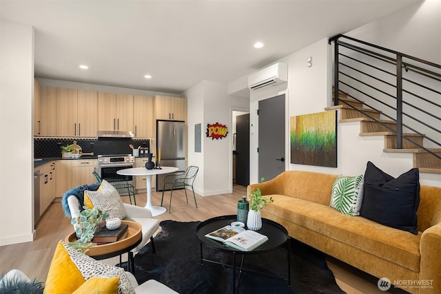 living room with light wood finished floors, recessed lighting, stairs, and a wall mounted AC