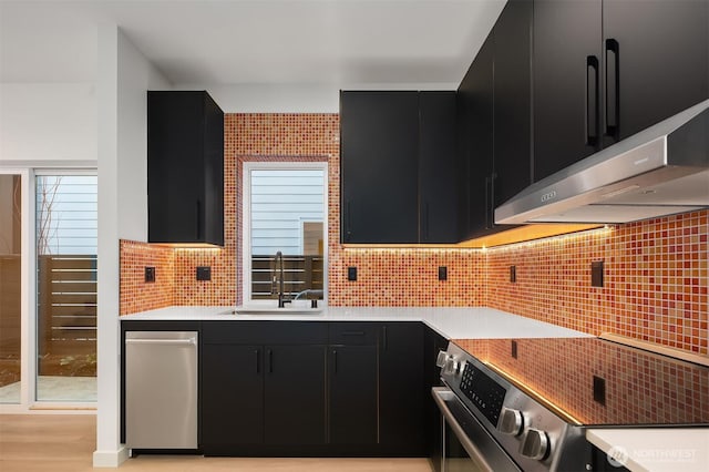 kitchen featuring dark cabinets, electric stove, a sink, and backsplash