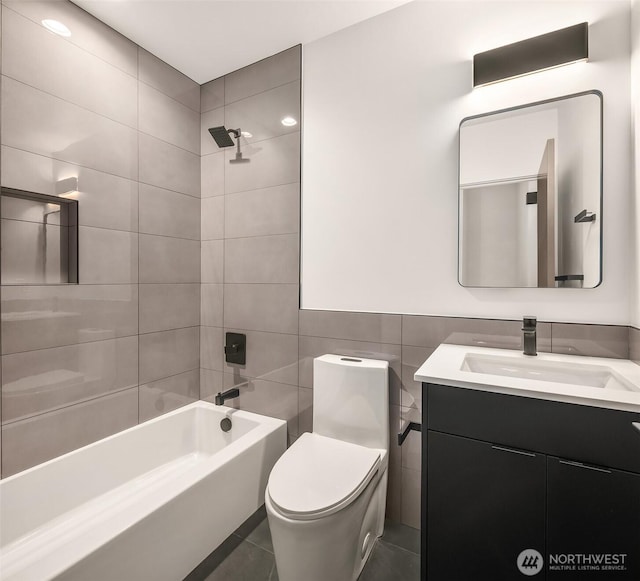 full bathroom with toilet, tile patterned flooring, tub / shower combination, vanity, and tile walls