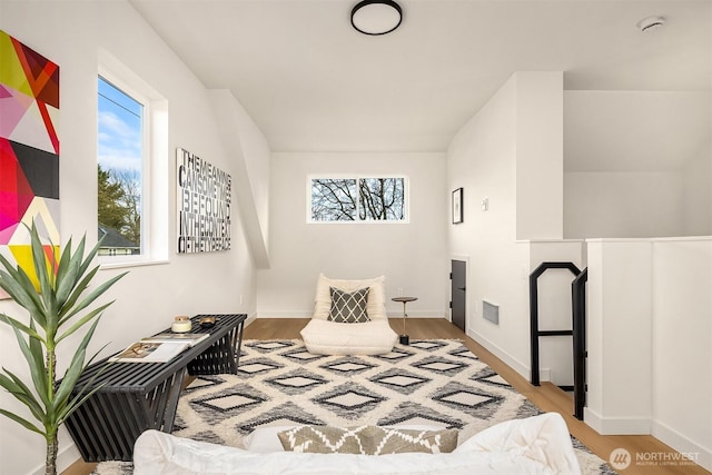 bedroom with baseboards, visible vents, and wood finished floors