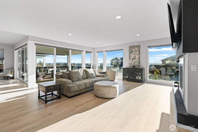 living room with recessed lighting, a healthy amount of sunlight, and wood finished floors