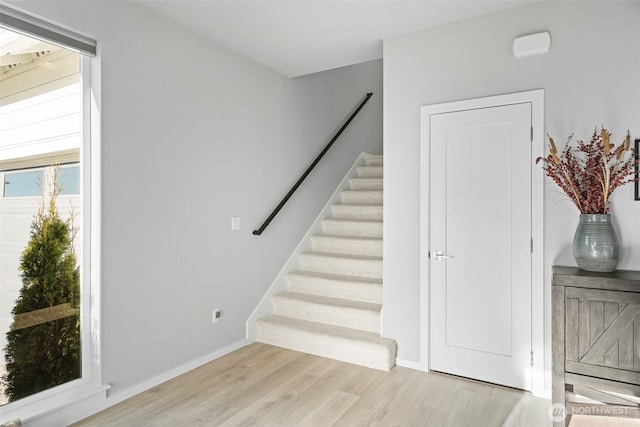 stairway with baseboards and wood finished floors