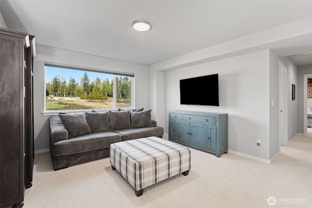 living area featuring light carpet and baseboards