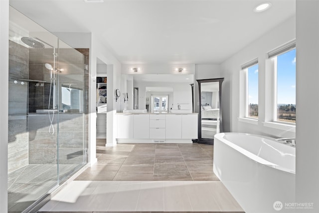 bathroom featuring a freestanding bath, a shower stall, and vanity