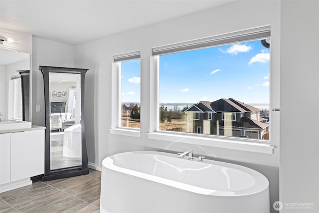 ensuite bathroom with a freestanding bath, vanity, and ensuite bathroom