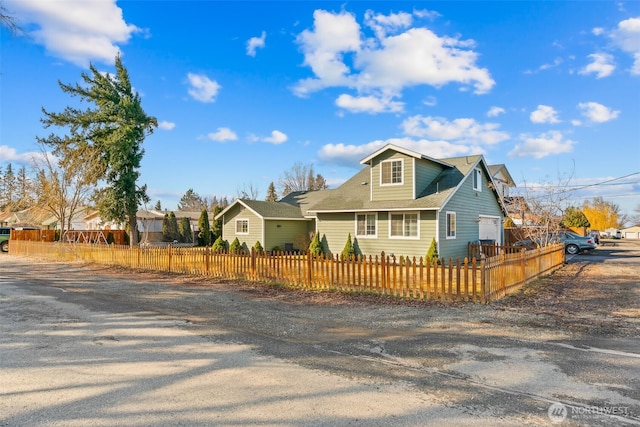 bungalow-style house featuring a garage and a fenced front yard