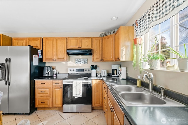 kitchen featuring light tile patterned floors, appliances with stainless steel finishes, a sink, and under cabinet range hood