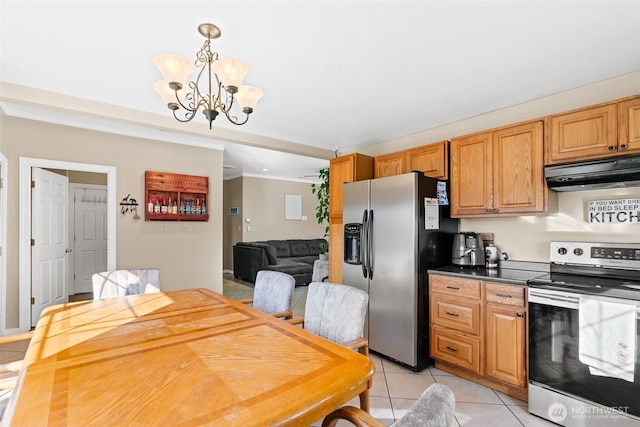 kitchen featuring light tile patterned floors, dark countertops, an inviting chandelier, stainless steel appliances, and under cabinet range hood