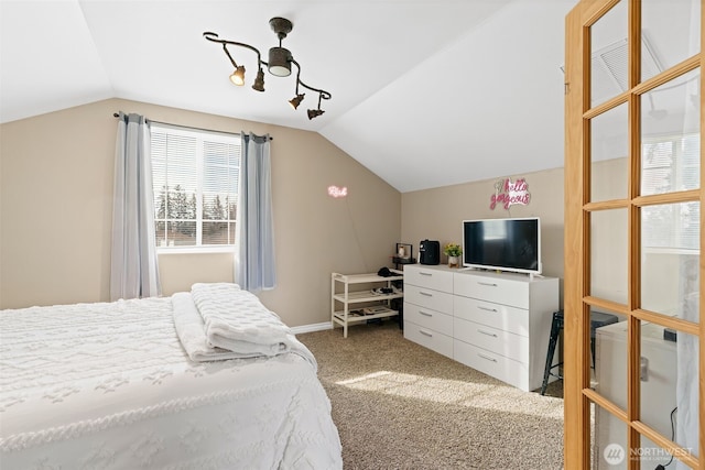 carpeted bedroom featuring lofted ceiling and baseboards