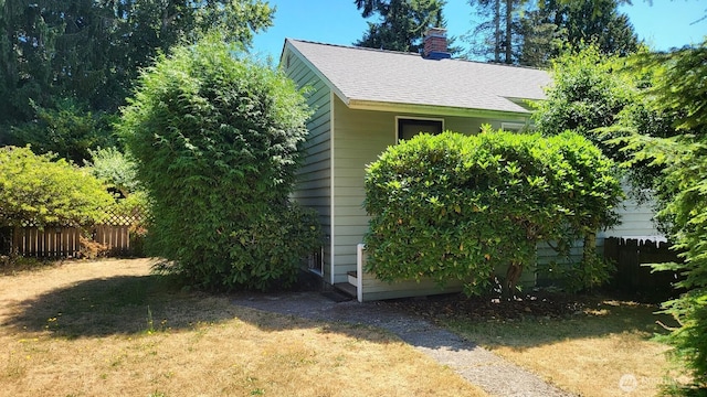 14934 5th Ave NE, Shoreline, WA 98155 - view of side of property featuring a chimney, a shingled roof, fence, and a yard