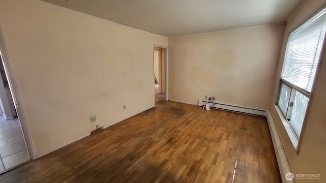 14934 5th Ave NE, Shoreline, WA 98155 - spare room featuring a baseboard radiator, baseboard heating, wood finished floors, and ornamental molding