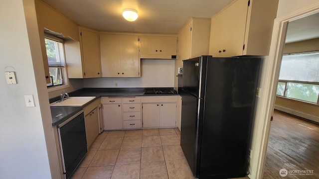 14934 5th Ave NE, Shoreline, WA 98155 - kitchen with light tile patterned flooring, a sink, dark countertops, black appliances, and cream cabinetry
