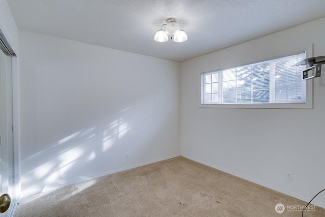 carpeted spare room featuring baseboards