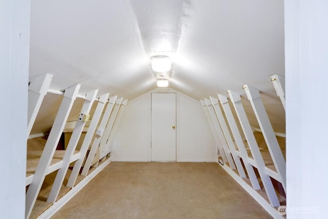 bonus room with lofted ceiling and light colored carpet