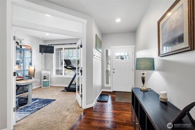 foyer featuring baseboards, dark carpet, dark wood finished floors, and recessed lighting