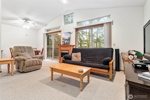 living room featuring lofted ceiling, a healthy amount of sunlight, a fireplace, and carpet