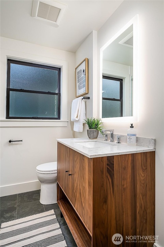 bathroom featuring vanity, toilet, baseboards, and visible vents