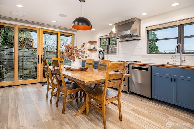 dining area with light wood finished floors and recessed lighting