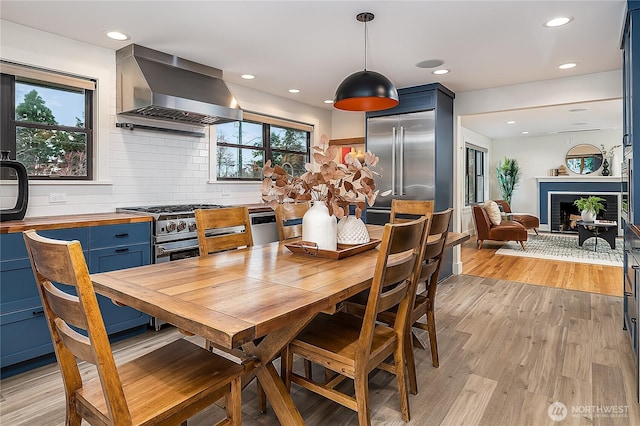 dining area with recessed lighting, light wood-style floors, and a fireplace