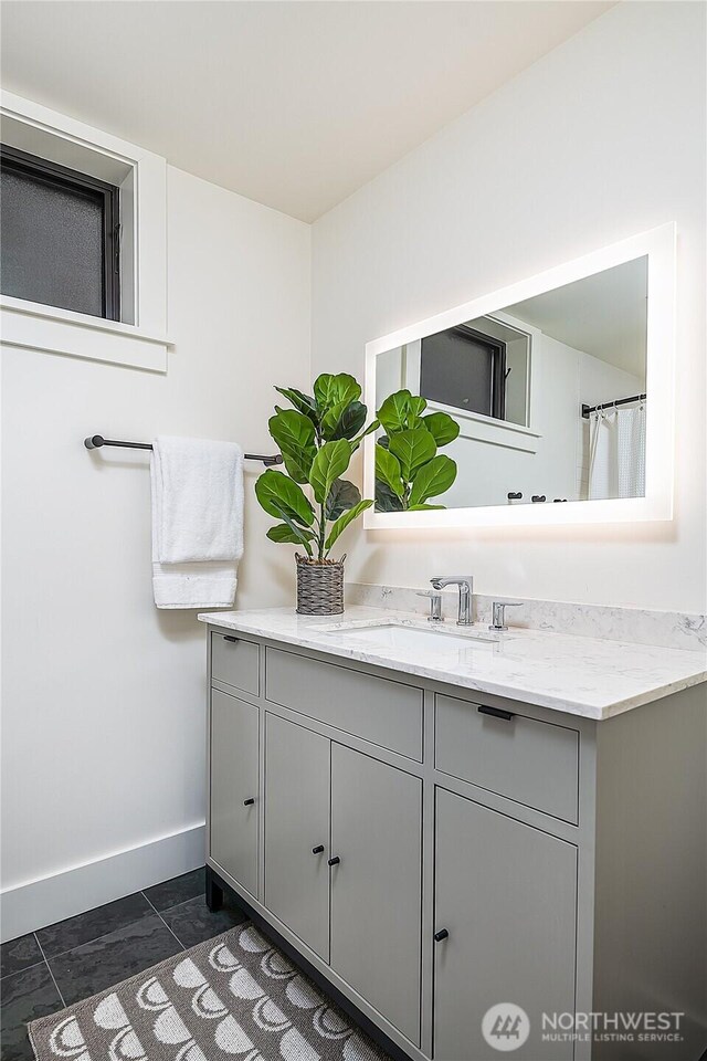 full bathroom featuring baseboards and vanity