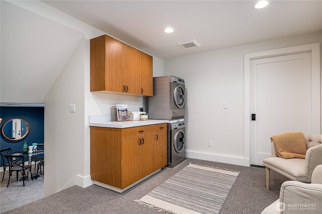 clothes washing area featuring visible vents, stacked washer and clothes dryer, recessed lighting, cabinet space, and baseboards