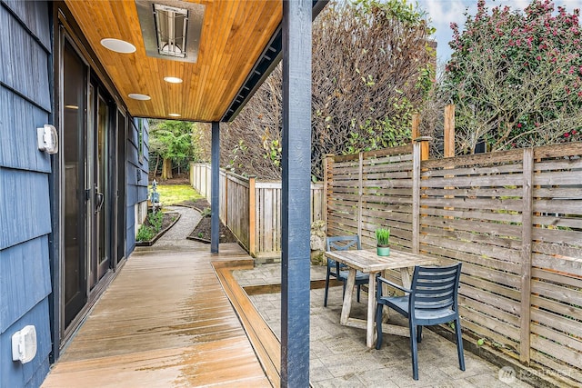 wooden terrace with a fenced backyard