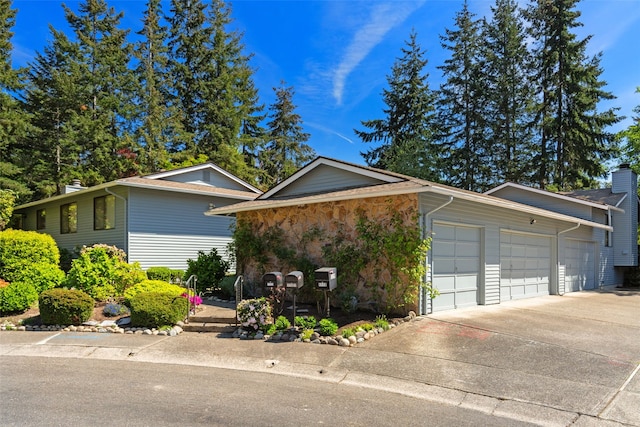 view of front facade with concrete driveway, an attached garage, and a chimney