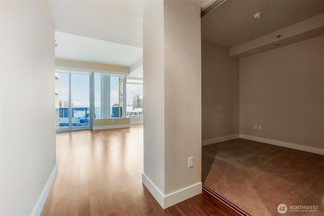 hallway with wood finished floors and baseboards