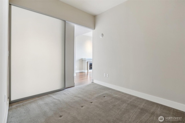 empty room featuring carpet floors and baseboards