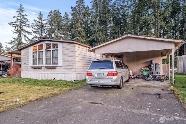 view of front of house featuring a carport, driveway, and a front lawn